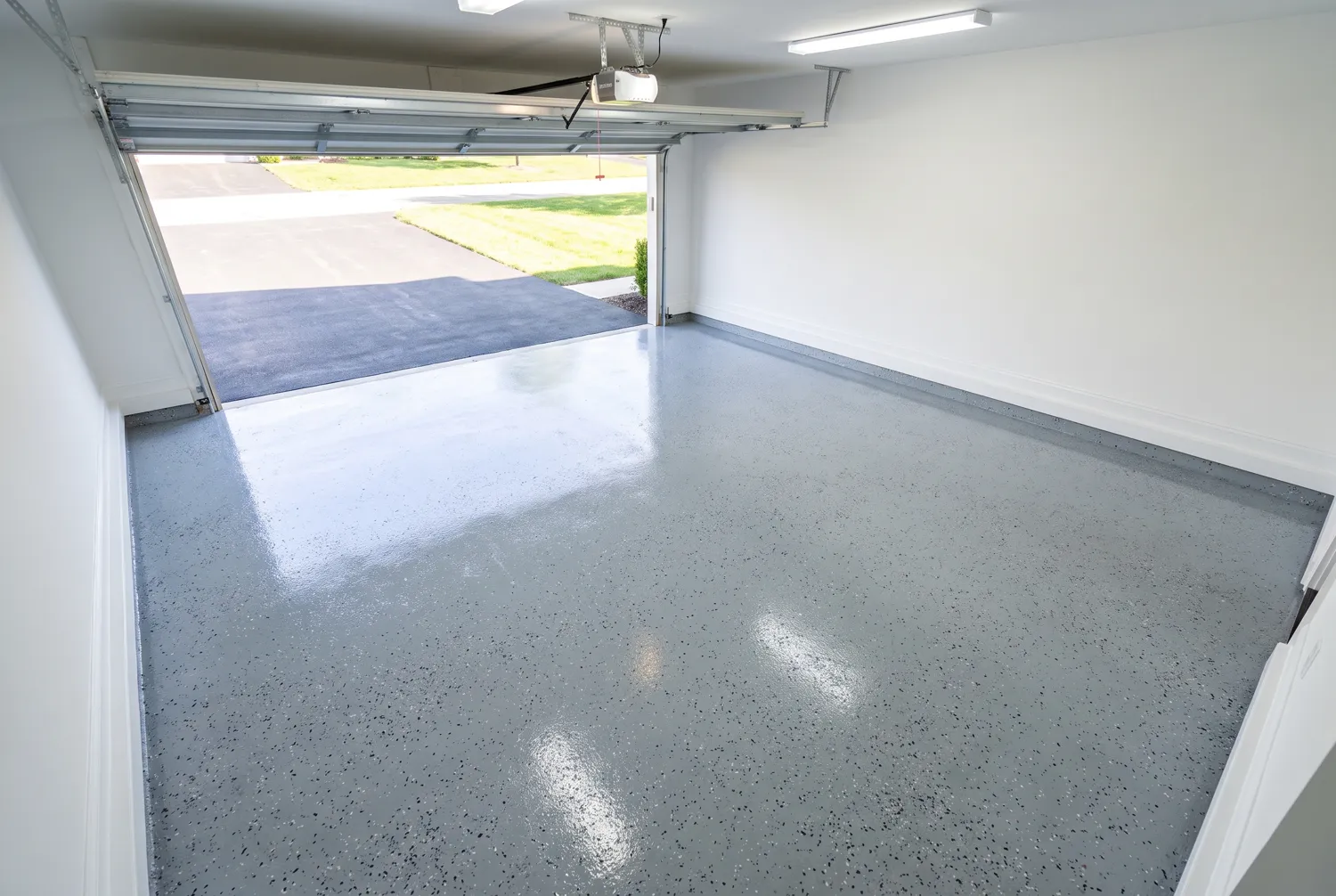 The same garage floor after coating, in glossy light grey epoxy with flake