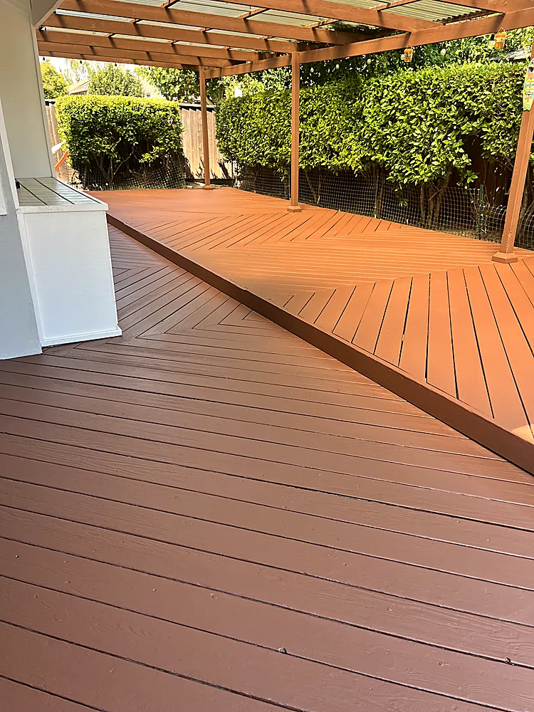 A large deck freshly stained a rich warm red brown with the grain showing