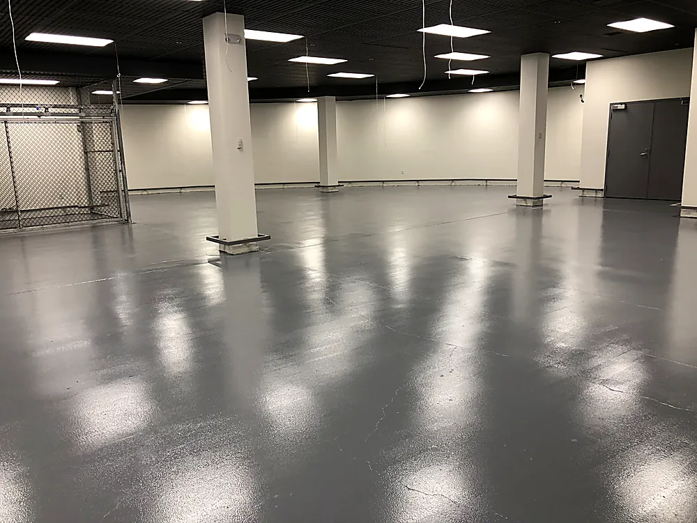 A large open commercial space with a smooth reflective grey coated floor