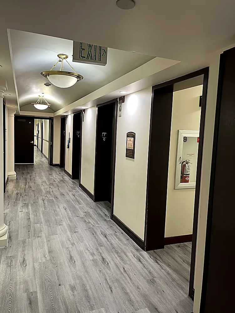 An interior hallway with bright white walls and charcoal painted doors and frames