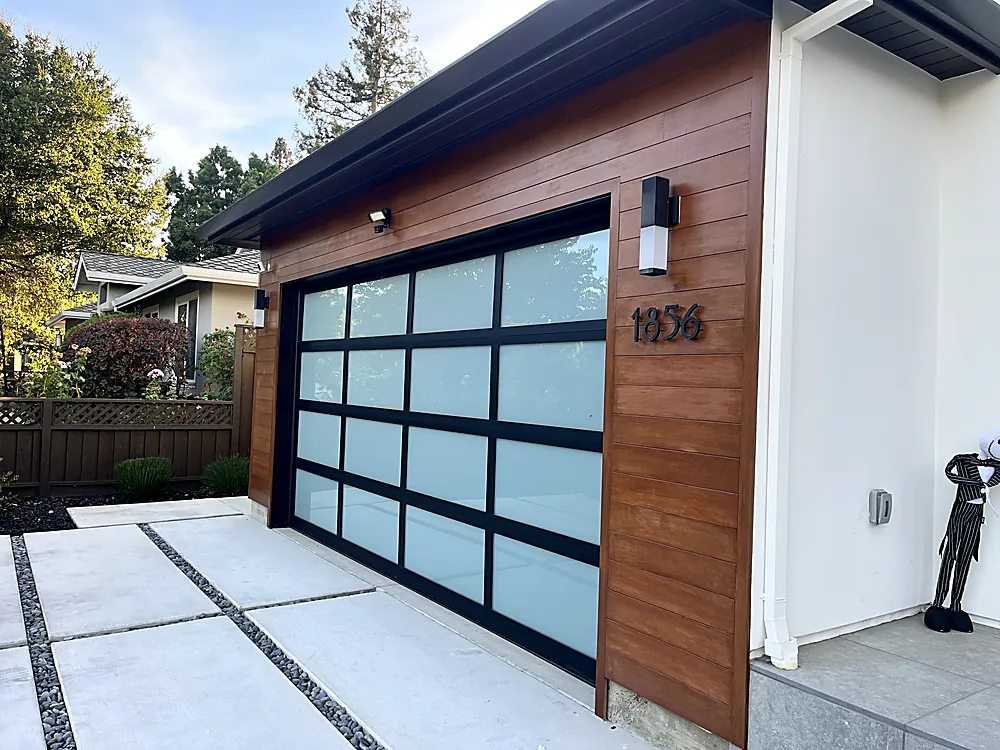A modern home with white walls and a glass and wood panelled garage door