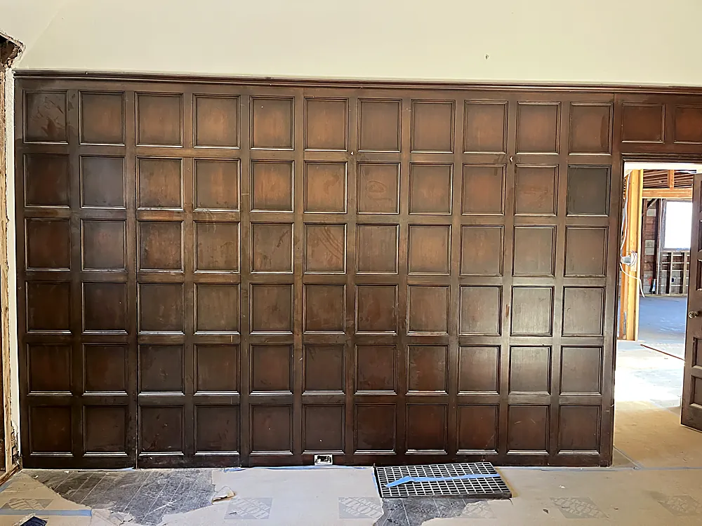 A large panelled feature wall refinished in a natural wood tone