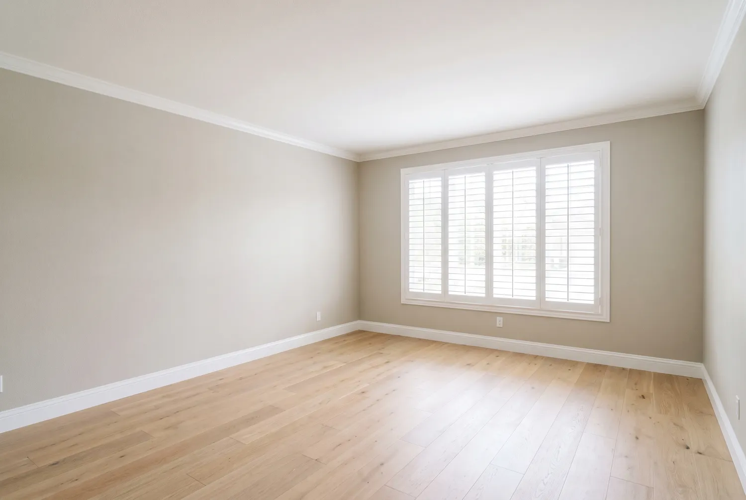 The same living room after painting, in soft warm greige with bright white trim