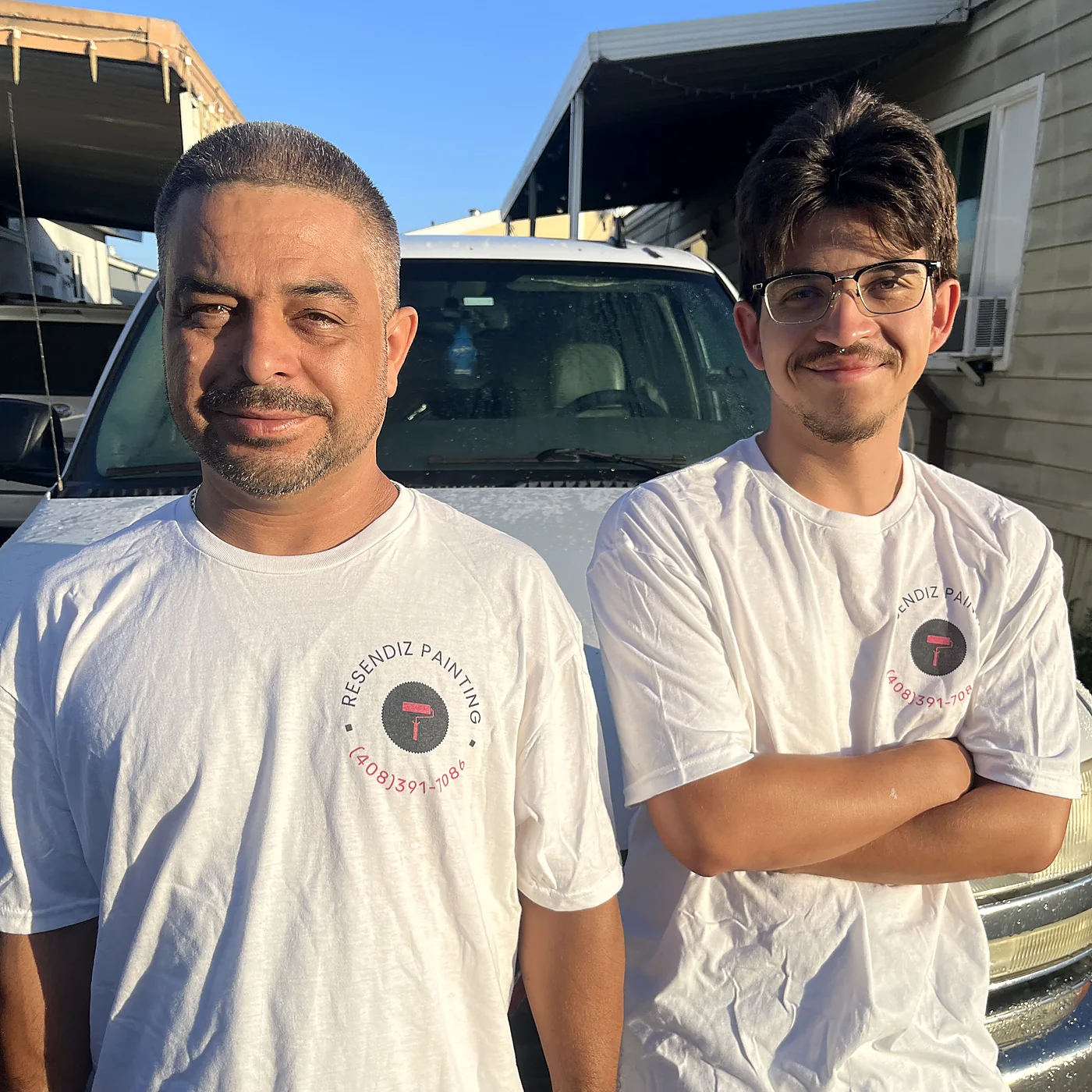Valente and Angel Resendiz in Resendiz Painting shirts, in front of the work truck